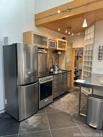 a kitchen with stainless steel appliances granite countertop a refrigerator and a sink