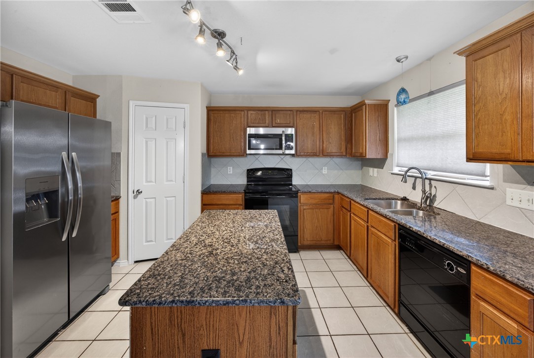 7015 Rickey Drive Temple, TX 76502 - Photo 9 of 29 a kitchen with stainless steel appliances granite countertop a sink stove and refrigerator