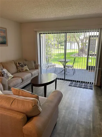 a living room with furniture and a floor to ceiling window