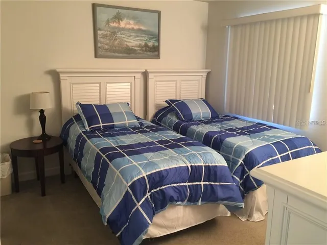 a bedroom with two beds and painting on the wall