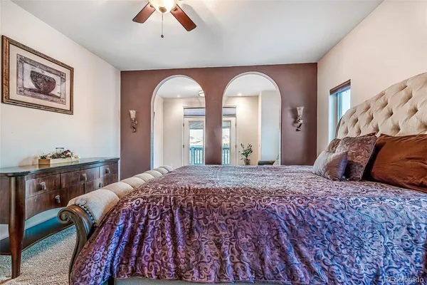 a bedroom with a large bed and a chandelier
