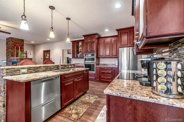 a kitchen with stainless steel appliances granite countertop a stove a sink and a refrigerator