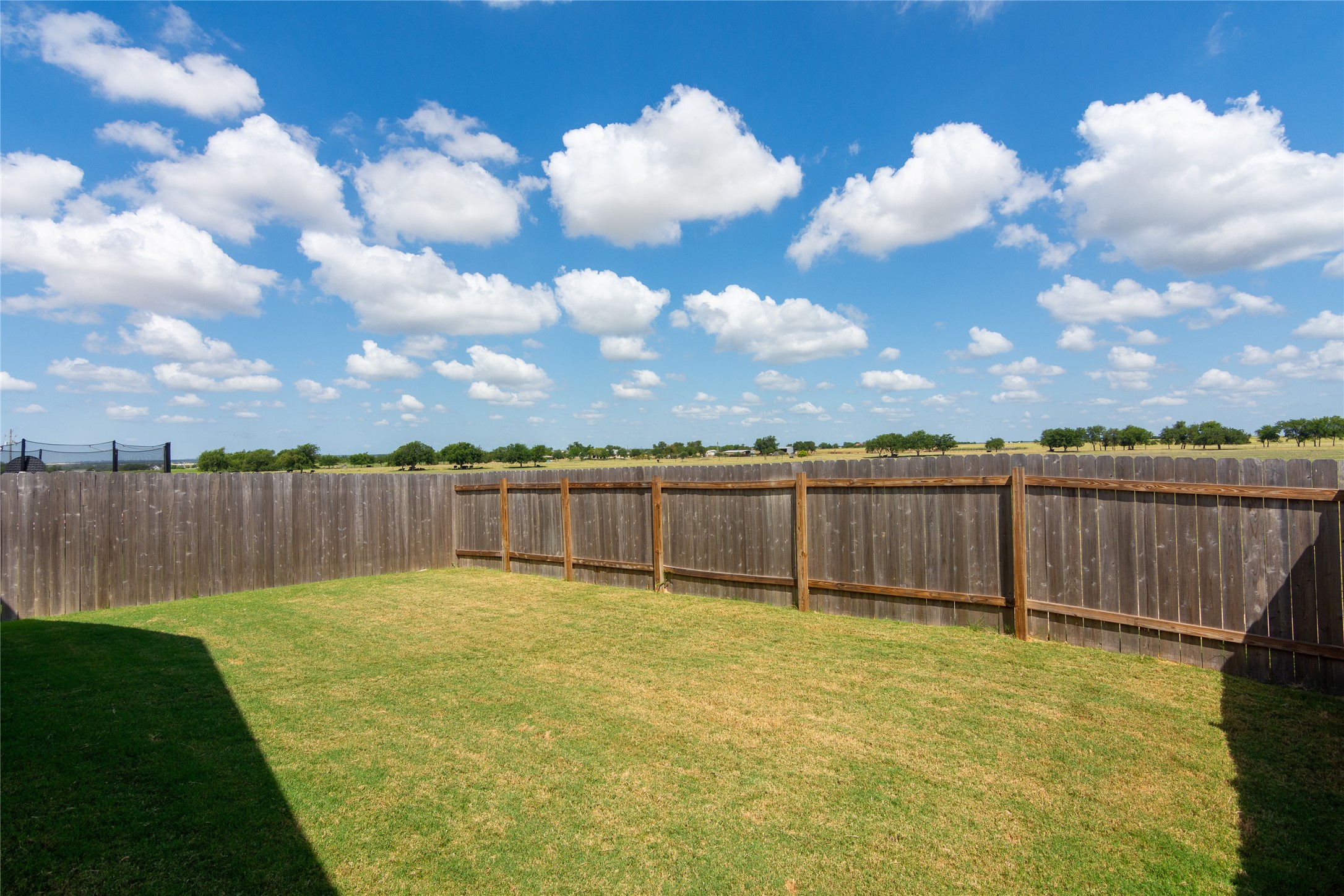 548 Rancho Del Cielo Loop Jarrell, TX 76537 - Photo 30 of 40 Fenced backyard with natural wood privacy fencing and expansive green space