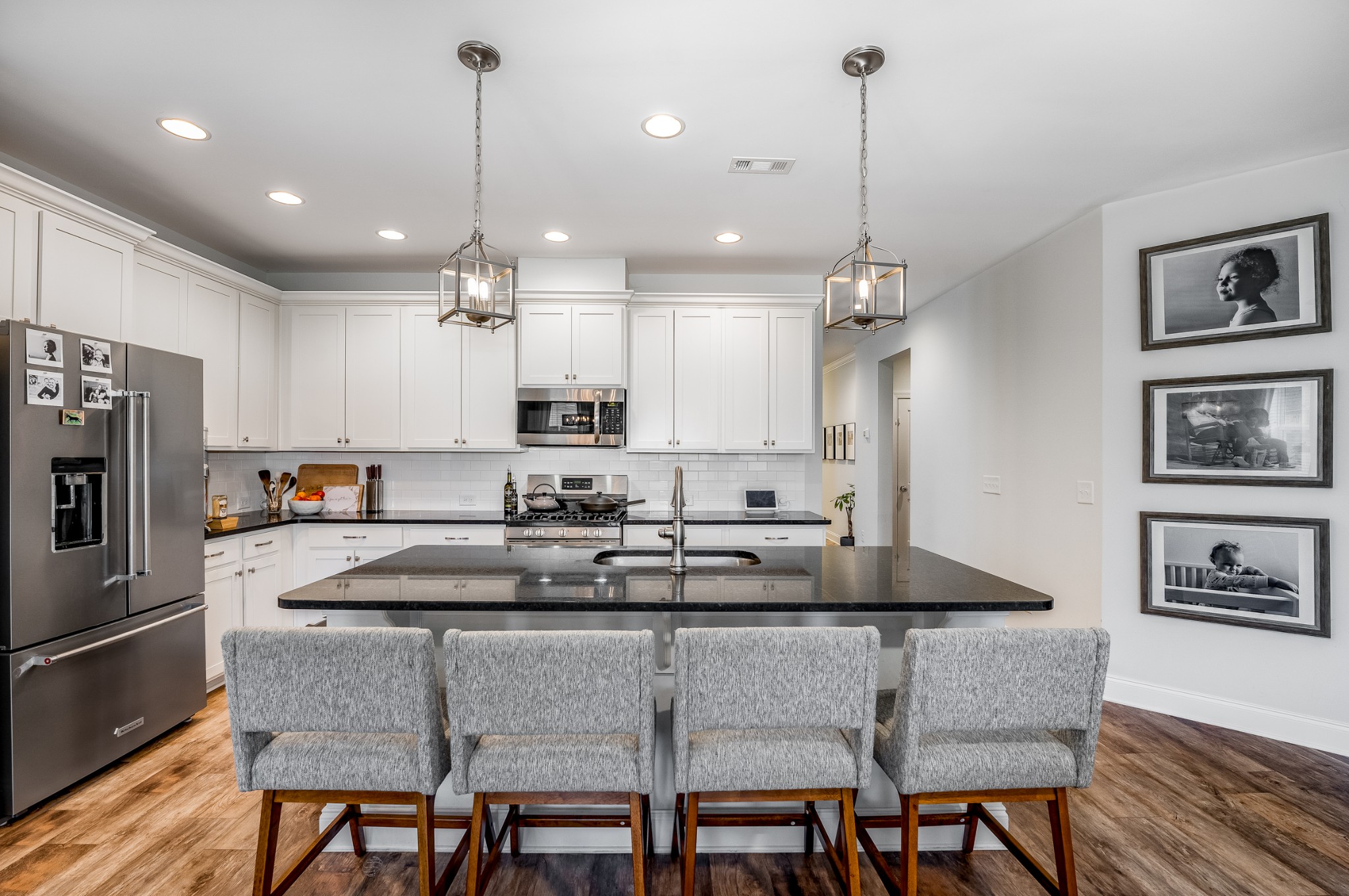 a kitchen with granite countertop a table chairs microwave and cabinets