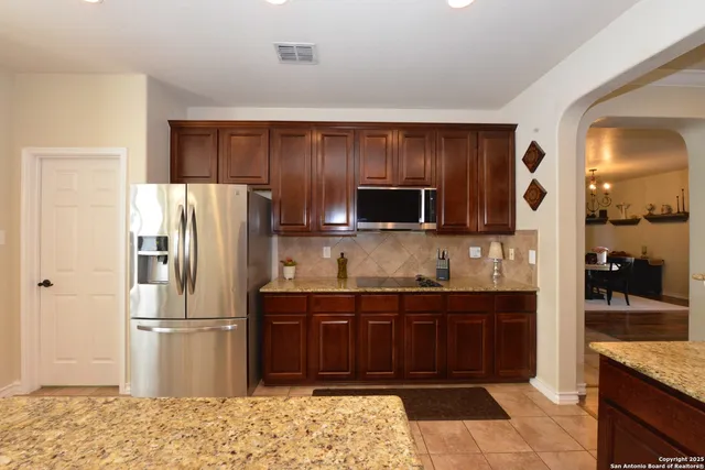 a kitchen with stainless steel appliances granite countertop a refrigerator and a sink