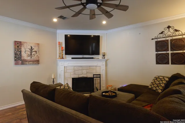 a living room with furniture a flat screen tv and a fireplace