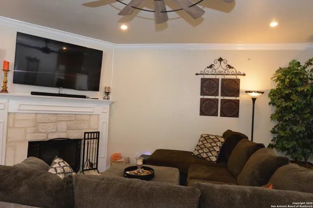 a living room with furniture a flat screen tv and a fireplace