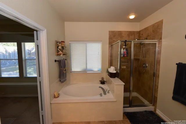 a bathroom with a tub a sink and a shower