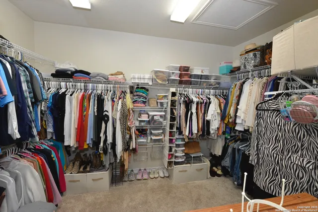 a view of walk in closet with clothes