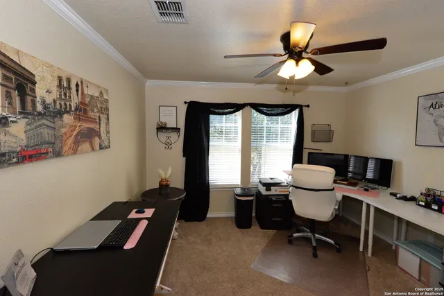 a view of a workspace with furniture and a window