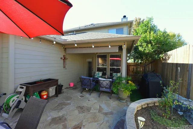 a patio with wooden table and chairs
