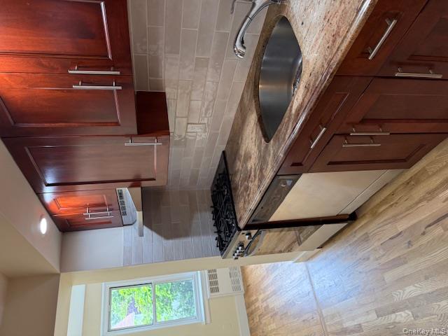 250 West Merrick Road, Unit 2R Freeport, NY 11520 - Photo 1 of 25 Kitchen featuring range, light stone countertops, light wood finished floors, dishwashing machine, and ventilation hood