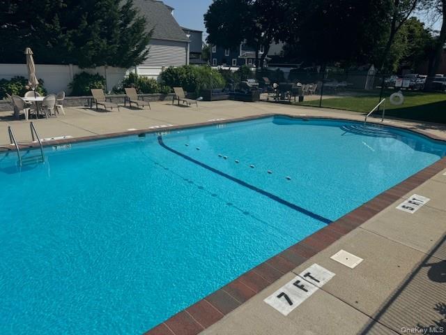 250 West Merrick Road, Unit 2R Freeport, NY 11520 - Photo 11 of 25 Community pool featuring a patio area