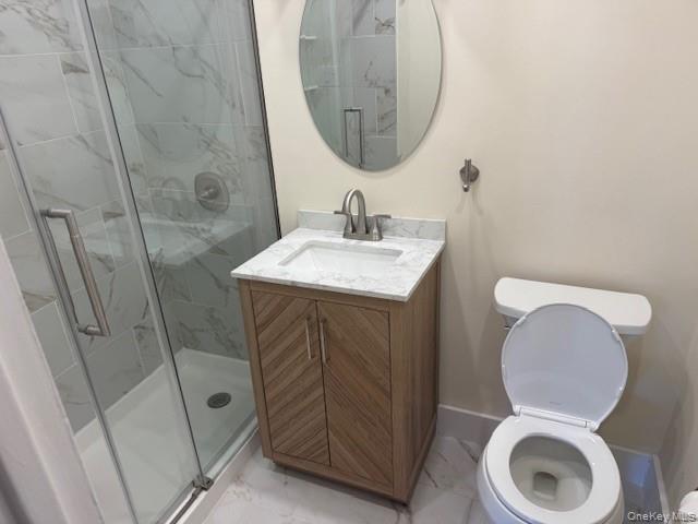 250 West Merrick Road, Unit 2R Freeport, NY 11520 - Photo 13 of 25 Bathroom featuring marble look tile flooring, a shower stall, and vanity