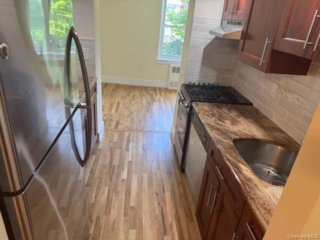 250 West Merrick Road, Unit 2R Freeport, NY 11520 - Photo 16 of 25 Kitchen with freestanding refrigerator, light wood-style floors, gas stove, and stone countertops