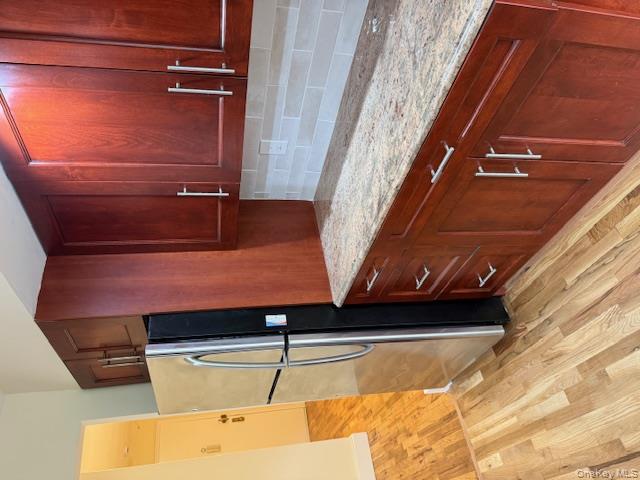 250 West Merrick Road, Unit 2R Freeport, NY 11520 - Photo 2 of 25 Kitchen with refrigerator, light wood-style flooring, light stone countertops, and reddish brown cabinets