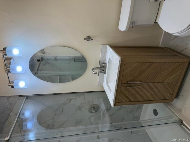 250 West Merrick Road, Unit 2R Freeport, NY 11520 - Photo 3 of 25 Full bath with marble look tiles, vanity, and a shower stall
