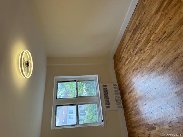 250 West Merrick Road, Unit 2R Freeport, NY 11520 - Photo 8 of 25 Empty room featuring radiator and wood finished floors
