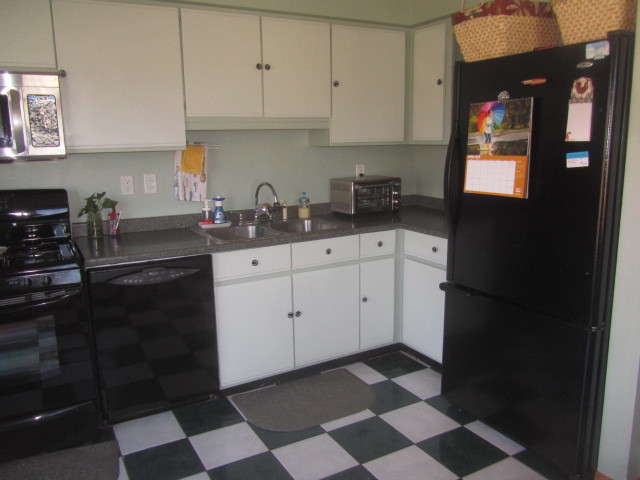25696 Raska Lane Lake Villa, IL 60046 - Photo 13 of 27 a kitchen with a checkered floor and white cabinets