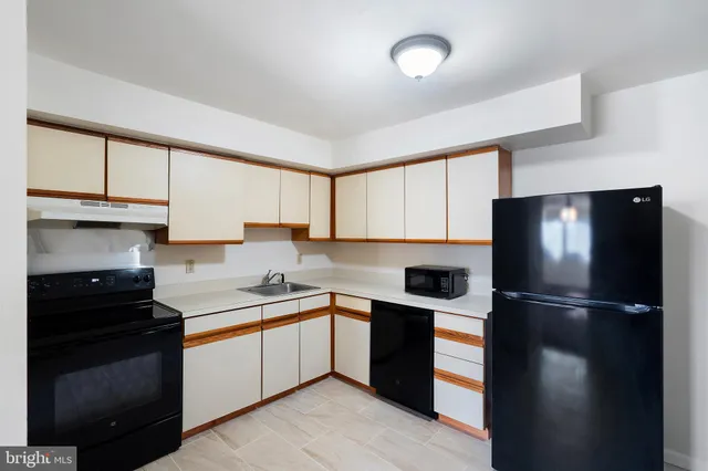 a kitchen with a sink a refrigerator and cabinets