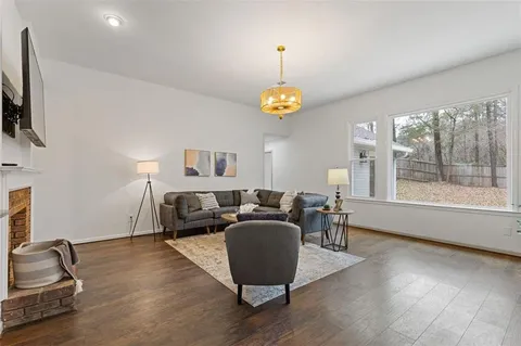 a living room with furniture flat screen tv and a large window
