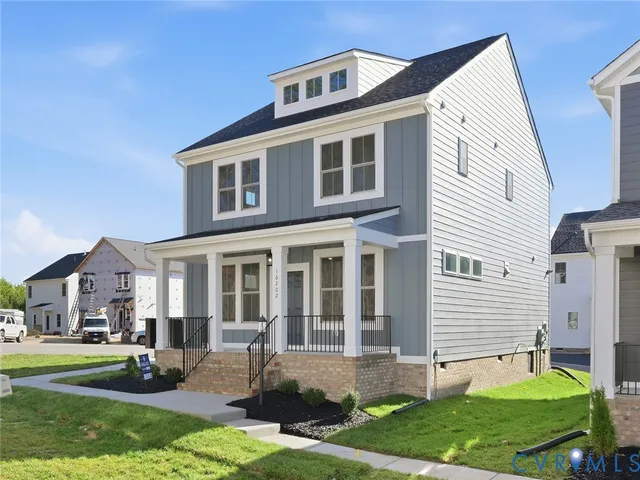 a front view of a house with a yard and trees