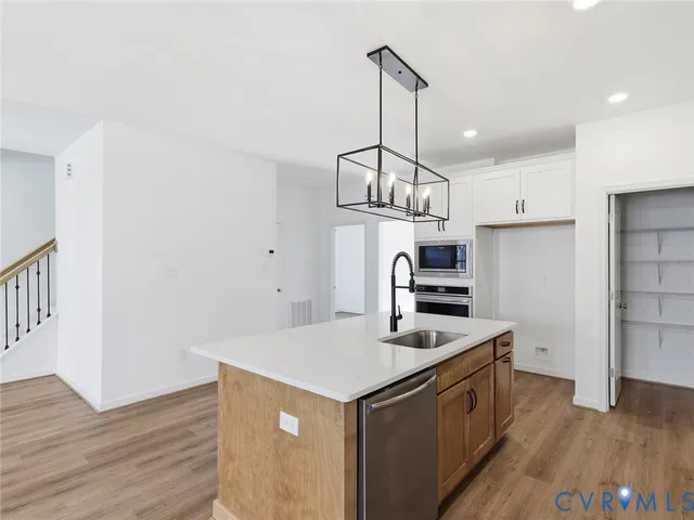 a kitchen that has a lot of cabinets and wooden floor