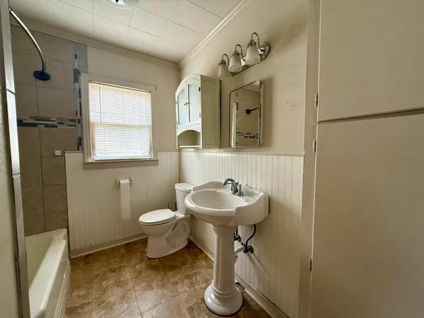 a bathroom with a toilet sink and mirror