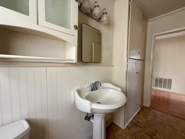 a bathroom with a sink and mirror with toilet