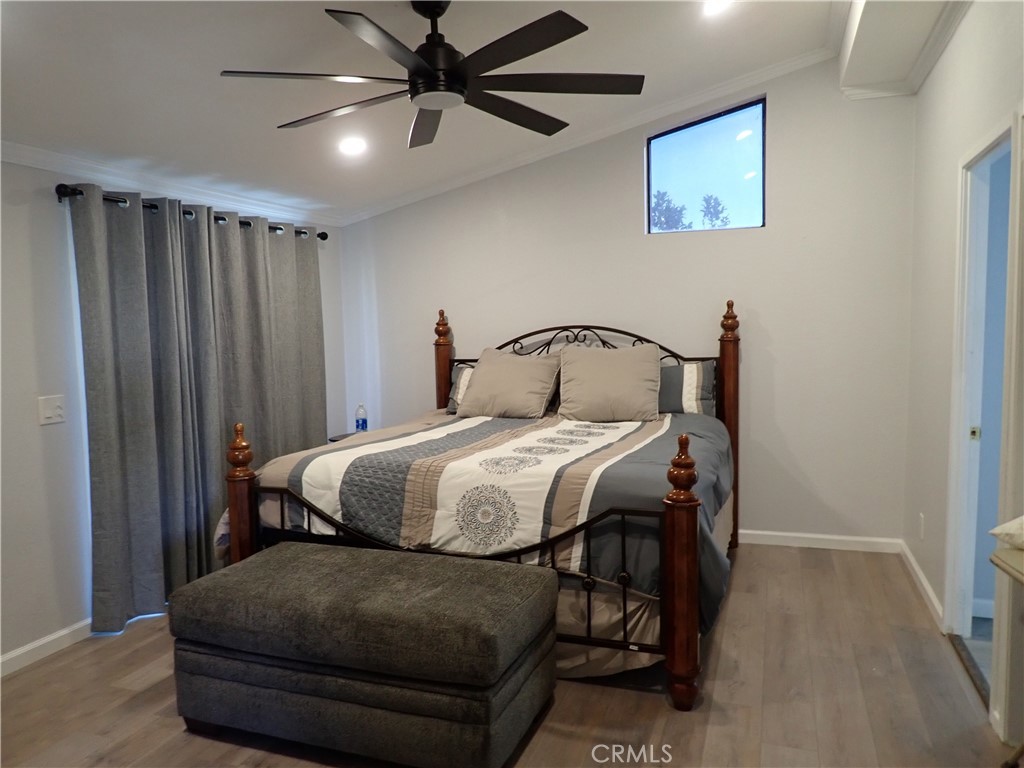 27250 Murrieta Road, Unit 386 Menifee, CA 92586 - Photo 20 of 32 a bedroom with a bed and wooden floor