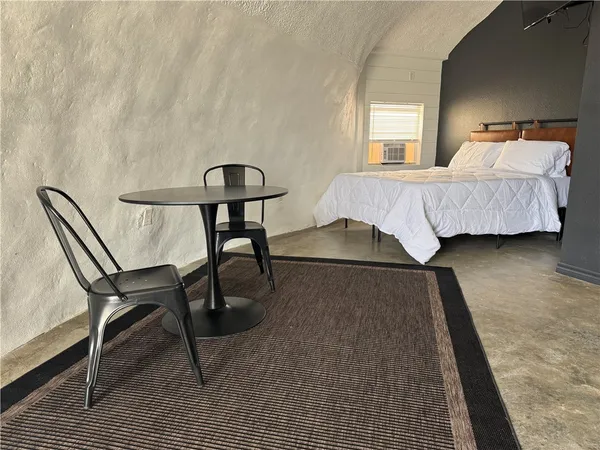 a bedroom with a bed chair and a table