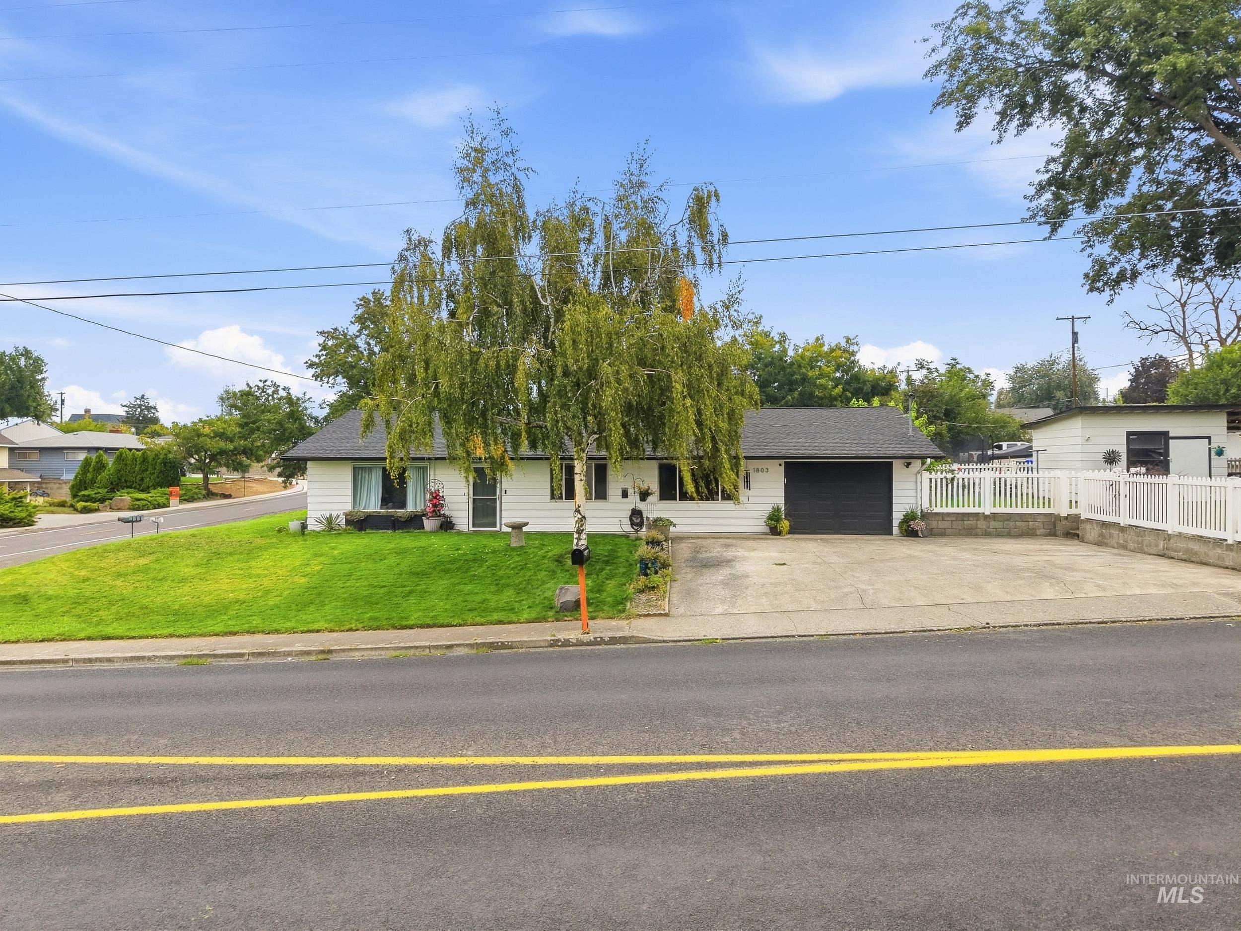 1803 14th Street Lewiston, ID 83501 - Photo 1 of 27 Single-story residence with white siding, dark roof, and an attached garage with a black door
