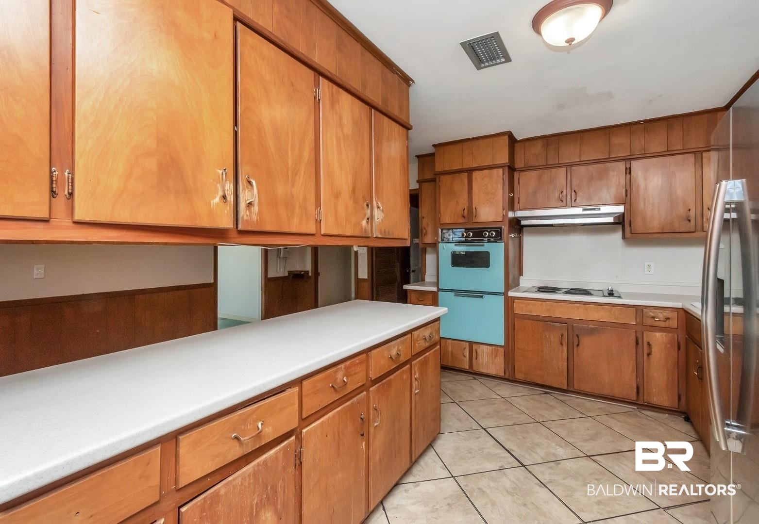 4543 Kingsway Drive Mobile, AL 36608 - Photo 10 of 28 Kitchen featuring visible vents, light countertops, multiple ovens, brown cabinetry, and under cabinet range hood