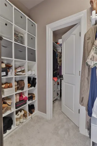 a view of walk in closet with clothes and shoes