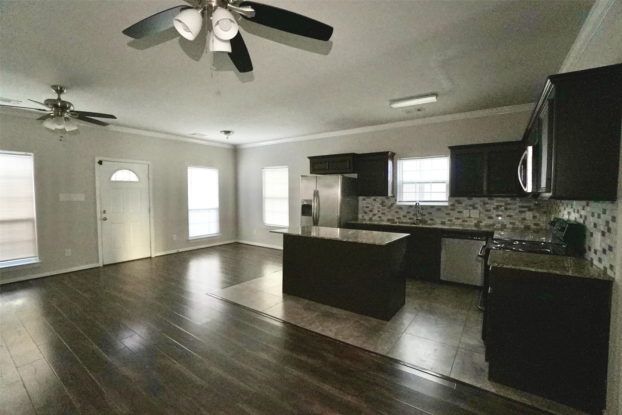 2523 Kirk Street, Unit B Houston, TX 77026 - Photo 3 of 16 a large kitchen with stainless steel appliances granite countertop a refrigerator a sink dishwasher a stove and a dining table with wooden floor