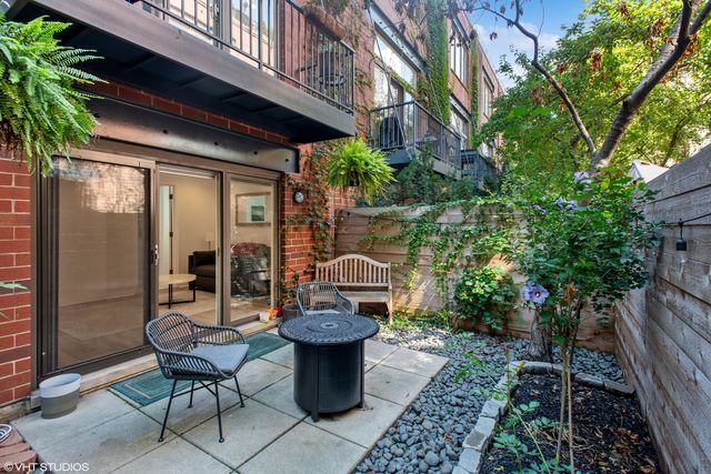 a view of a chair and table in backyard of the house