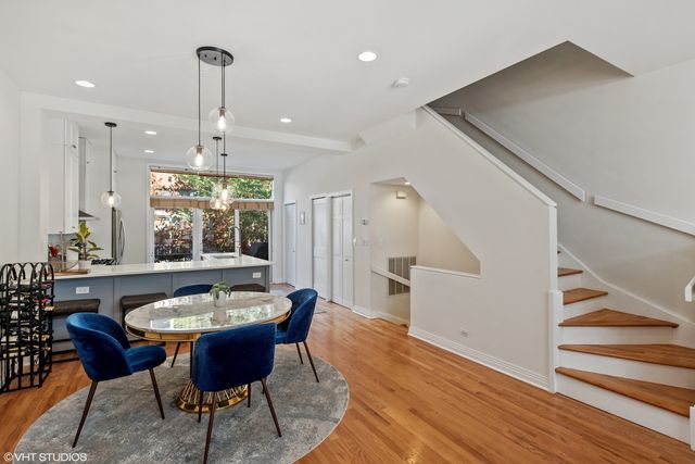 a dining room with furniture a chandelier and wooden floor