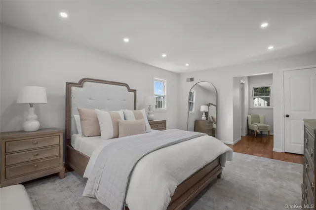 a spacious bedroom with a bed and a lamp