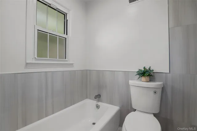 a white toilet sitting next to a bathroom sink