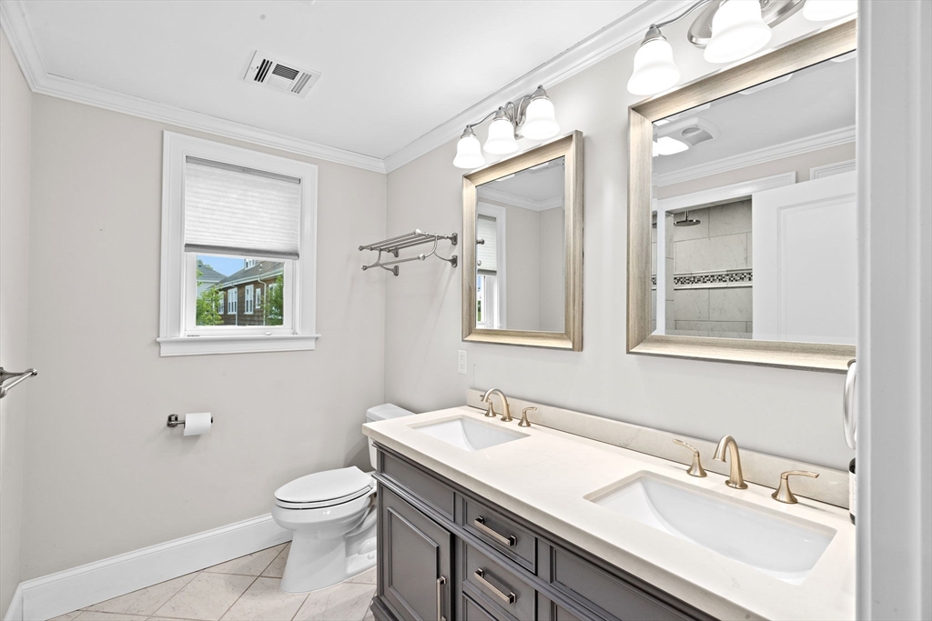 19 Damon Road Scituate, MA 02066 - Photo 21 of 29 a bathroom with a toilet a sink a mirror and a window