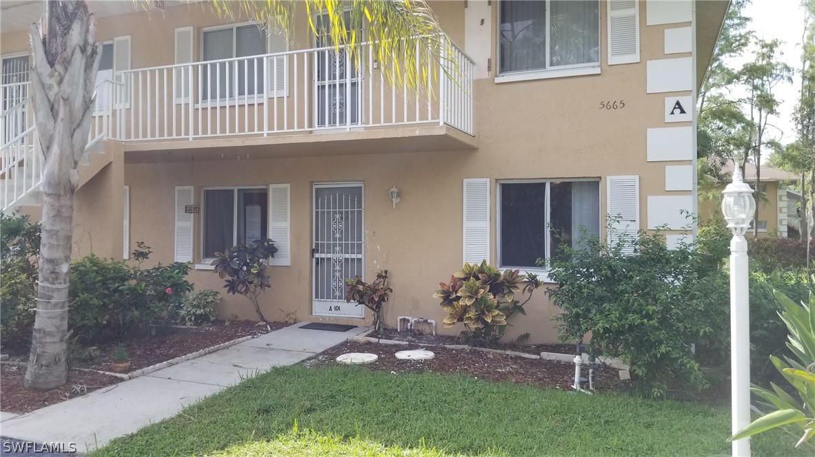 5665 Whitaker Road, Unit A101 Naples, FL 34112 - Photo 1 of 17 front view of a house with a yard