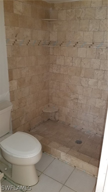 5665 Whitaker Road, Unit A101 Naples, FL 34112 - Photo 15 of 17 a white toilet sitting next to a bath tub