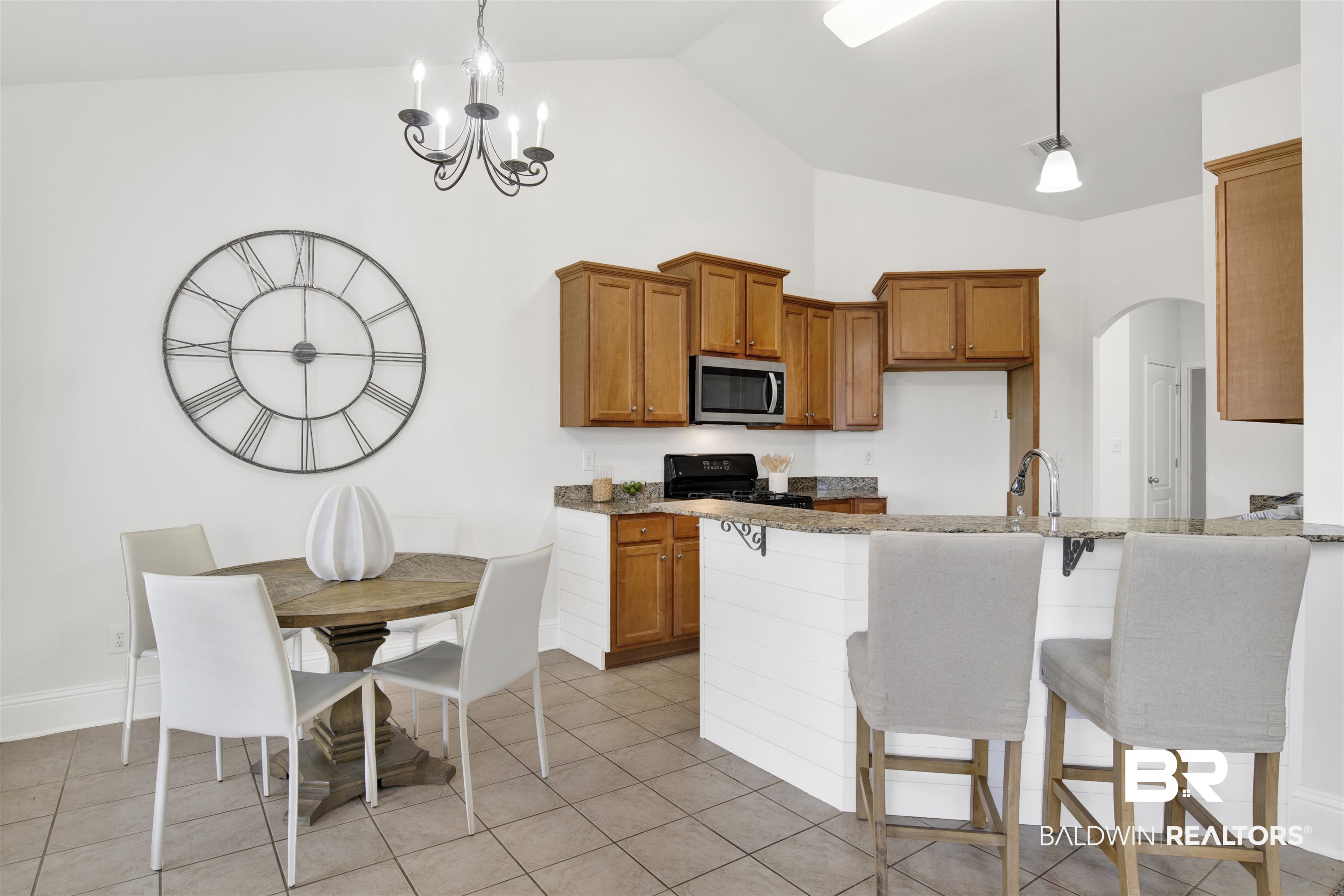 25350 Spindle Lane Daphne, AL 36526 - Photo 13 of 32 Kitchen with pendant lighting, sink, light stone countertops, a kitchen bar, and black range oven