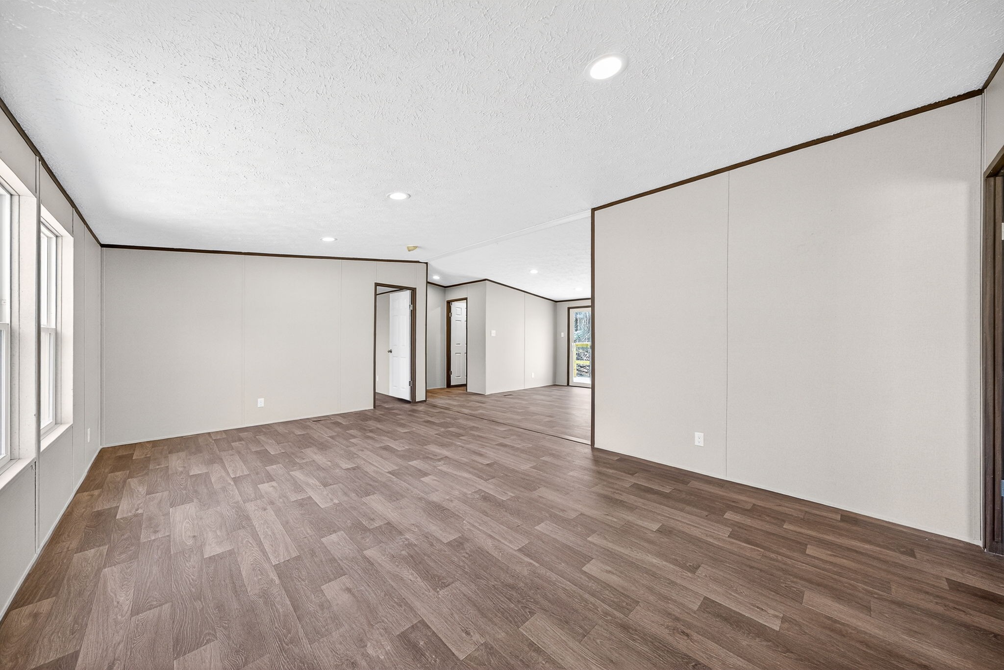 428 Maple Branch Road Sparta, TN 38583 - Photo 10 of 28 a view of a big room with wooden floor and windows with curtains