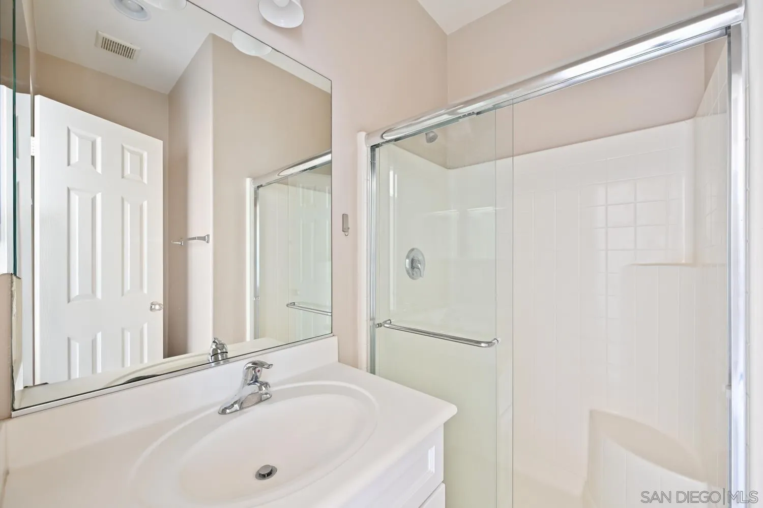 5074 Cascade Way, Unit 102 Oceanside, CA 92057 - Photo 23 of 30 a bathroom with a white sink a shower and a mirror