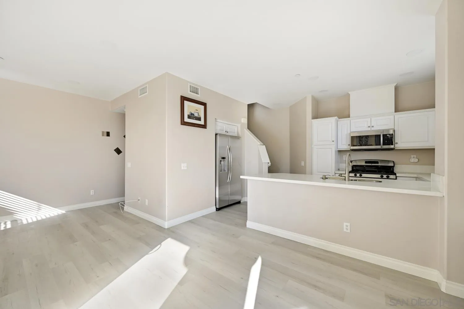 5074 Cascade Way, Unit 102 Oceanside, CA 92057 - Photo 6 of 30 a living room with stainless steel appliances furniture a refrigerator and a counter top