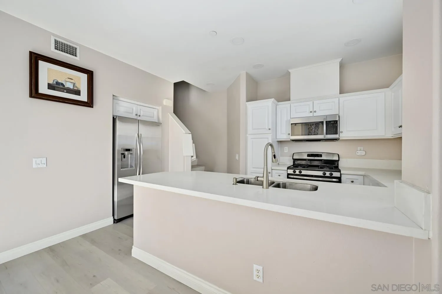5074 Cascade Way, Unit 102 Oceanside, CA 92057 - Photo 8 of 30 a kitchen with stainless steel appliances a refrigerator sink stove and microwave