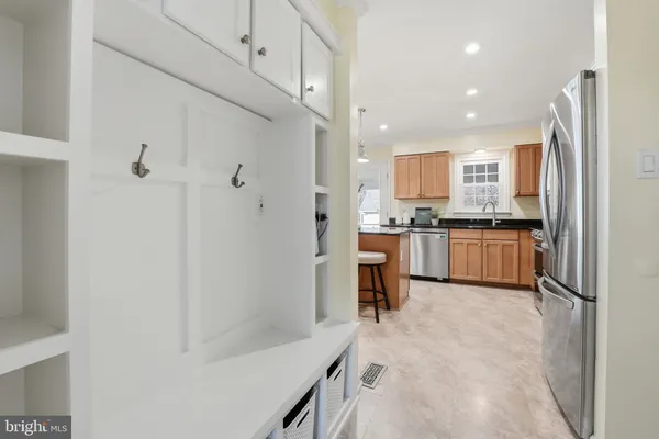 a kitchen with stainless steel appliances granite countertop a refrigerator a sink dishwasher a stove with wooden cabinets and floor