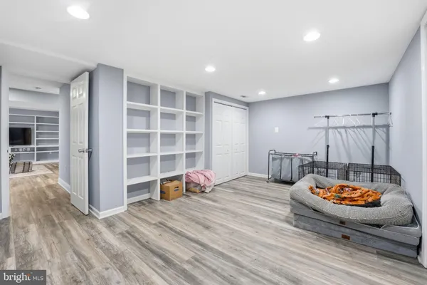 a view of an empty room with wooden floor and closet