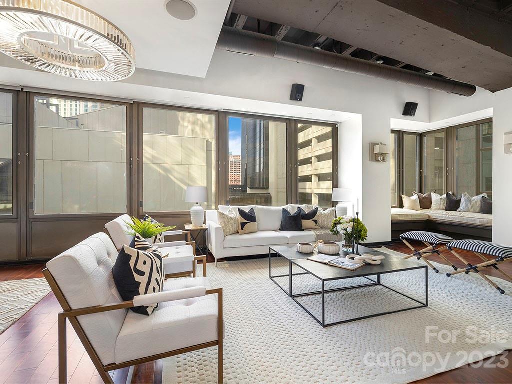 139 South Tryon Street, Unit 3B Charlotte, NC 28202 - Photo 15 of 21 a living room with furniture and floor to ceiling windows